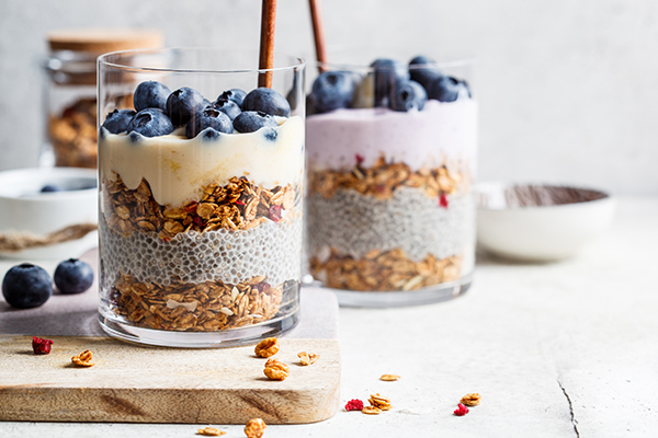 Breakfast parfait with chia, granola, berries and yogurt in a glass.