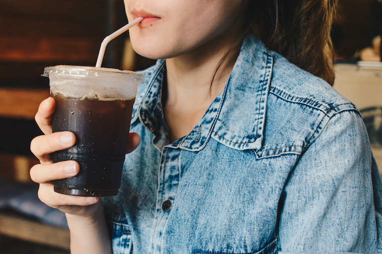 woman sipping iced coffee