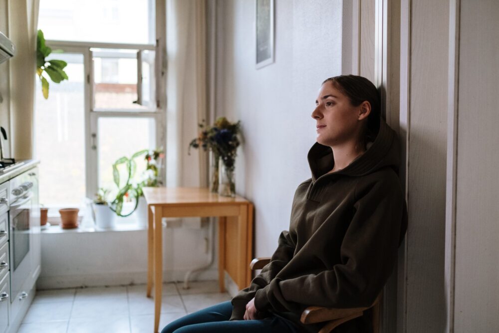 woman sitting in a hallway upset