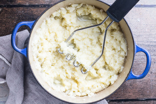 mashing cauliflower in a pot for low carb keto alternatives to mashed potatoes