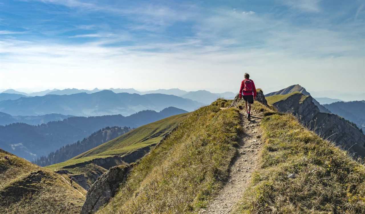 A man solo hiking on a mountain with a sweeping view of the distant landscape