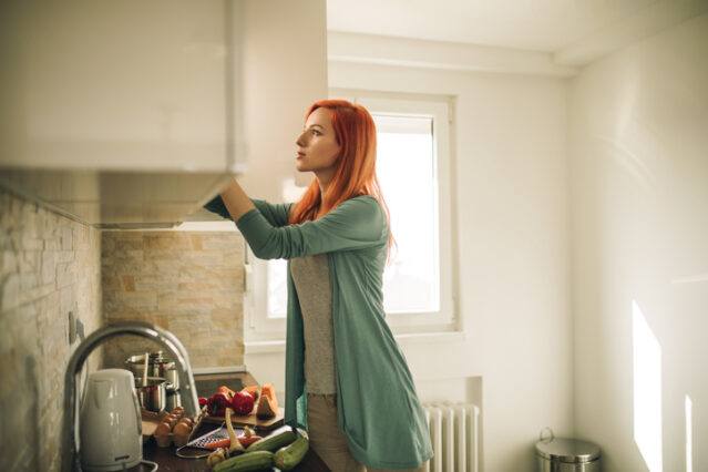 woman cleaning out her pantry doing a kitchen purge