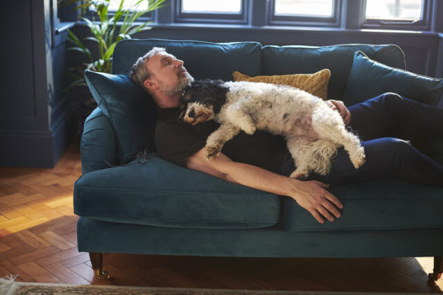 man and dog sleeping on the sofa