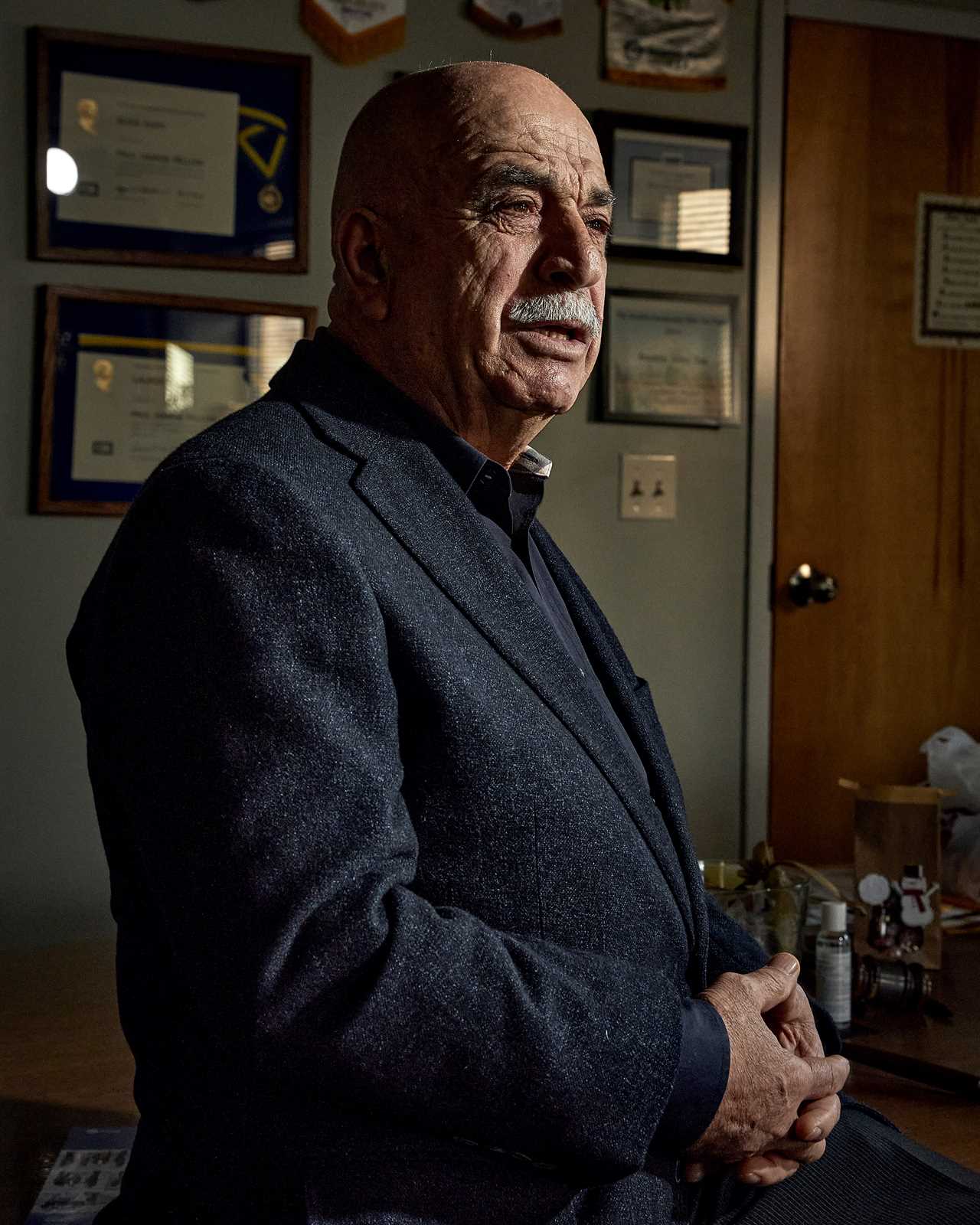 DECEMBER 5 2021 - Brookline, Mass.,which recently became the first town in the United States to ban tobacco sales based not on current age, but on birth date: anyone born after Jan. 1, 2000 will never be able to buy tobacco there, no matter how old they are. Portrait of Elias Audy who owns and operates the Village Mobil in Brookline Hills off of Route 9. Eilas is photographed in his office which is decorated with awards and memorabilia from his time serving with the Brookline Rotary Club.