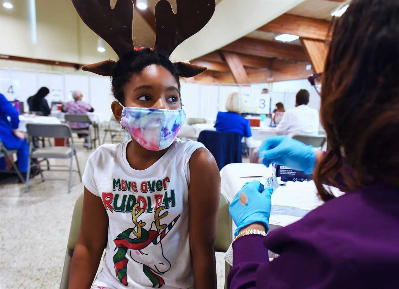 A health worker prepares to administer a dose of Pfizer