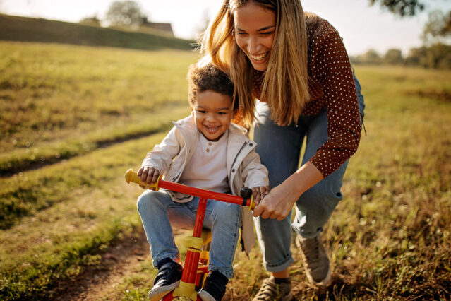 mother teaching son to ride a bike as her new years resolution for more time with family