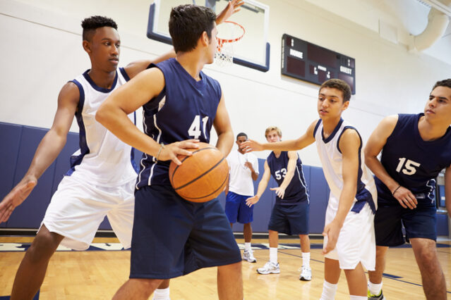 teens at basketball practice in a high school gymnasium