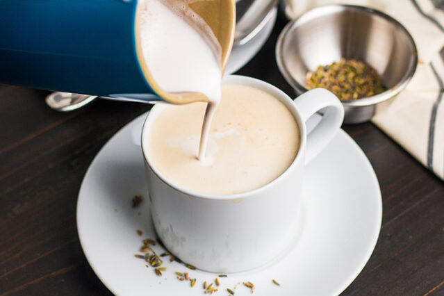 pouring frothed milk into a mug of tea for a london fog latte