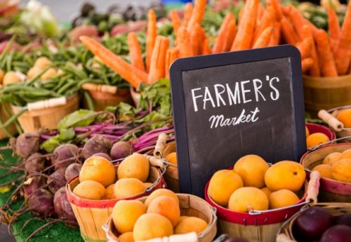 Baskets of fruits and vegetables displayed at a farmer's market.