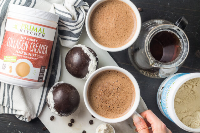 Two cups of coffee with chocolate collagen bombs, Primal Kitchen Hazelnut and Vanilla Collagen Fuel canisters