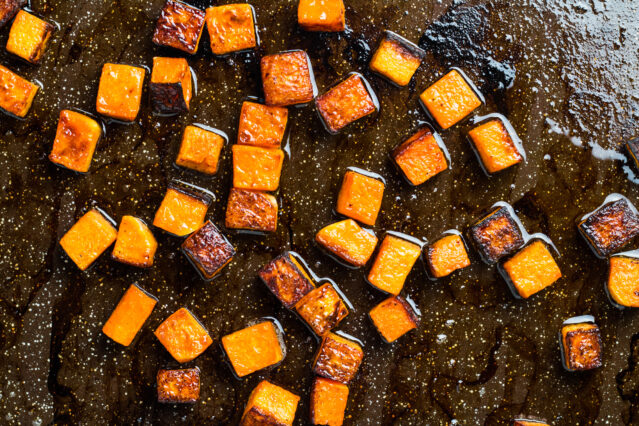 Roasted cubed butternut squash on a roasting pan