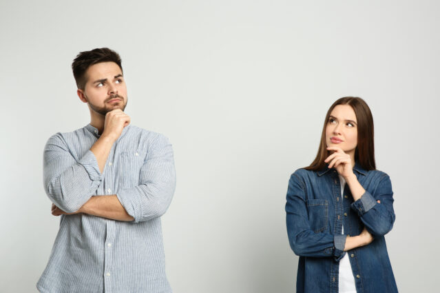 Pensive man and woman on light background. 