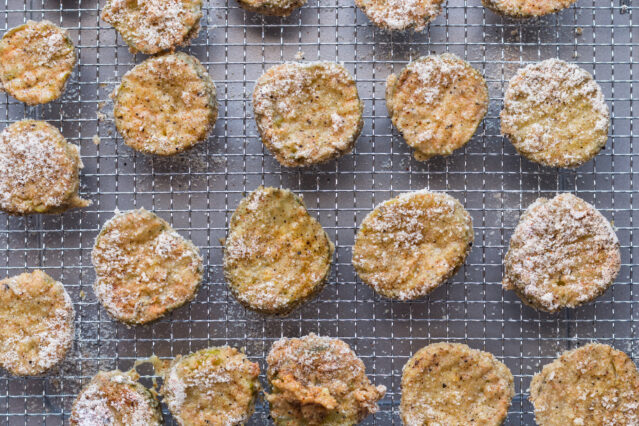 Air fried pickle slices on a rack.