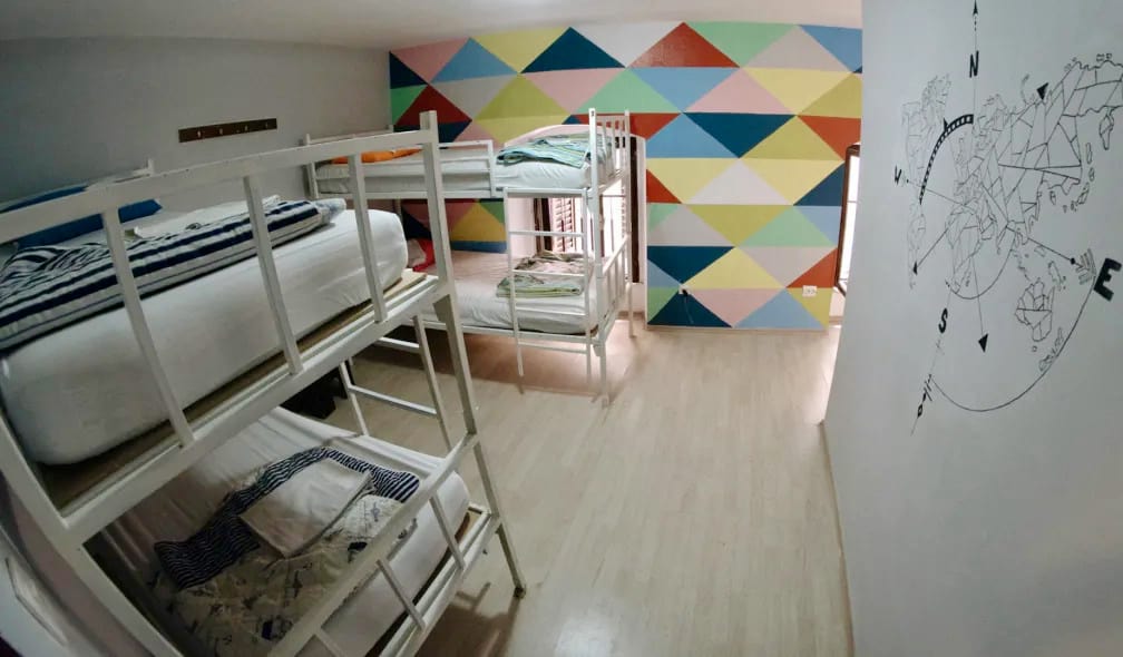 The interior of a small dorm with bunk beds and a map on the wall in the Fiesta Siesta Hostel in Split, Croatia