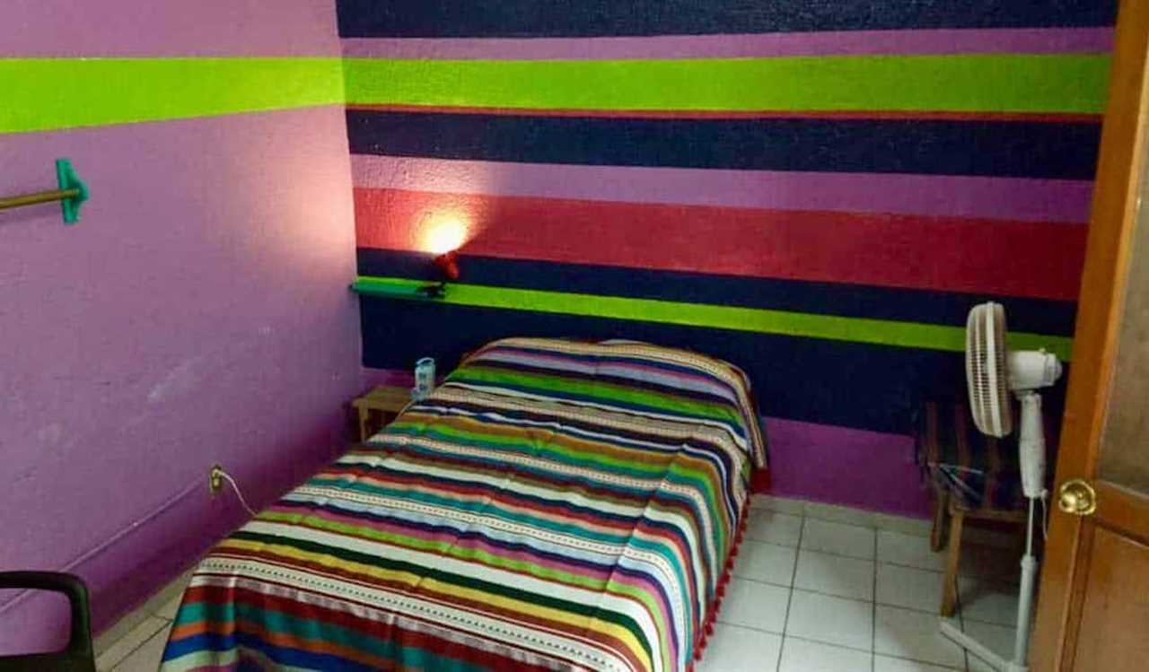 A colorful single bed at the budget-friendly Iguana Hostel in Oaxaca, Mexico