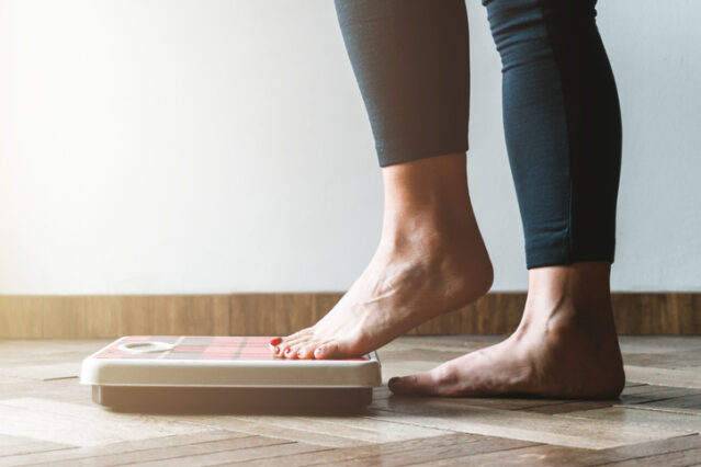 Feet stepping on a weighing scale