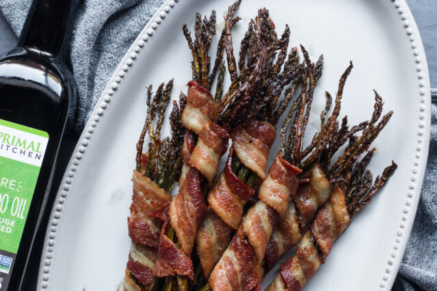 Bacon wrapped asparagus on white plate