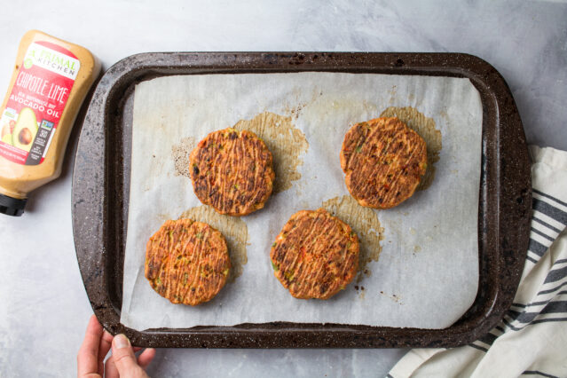 Cooked salmon burgers on a baking sheet