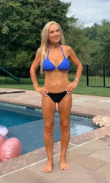 Elizabeth stands in front of a pool wearing blue and black bikini.
