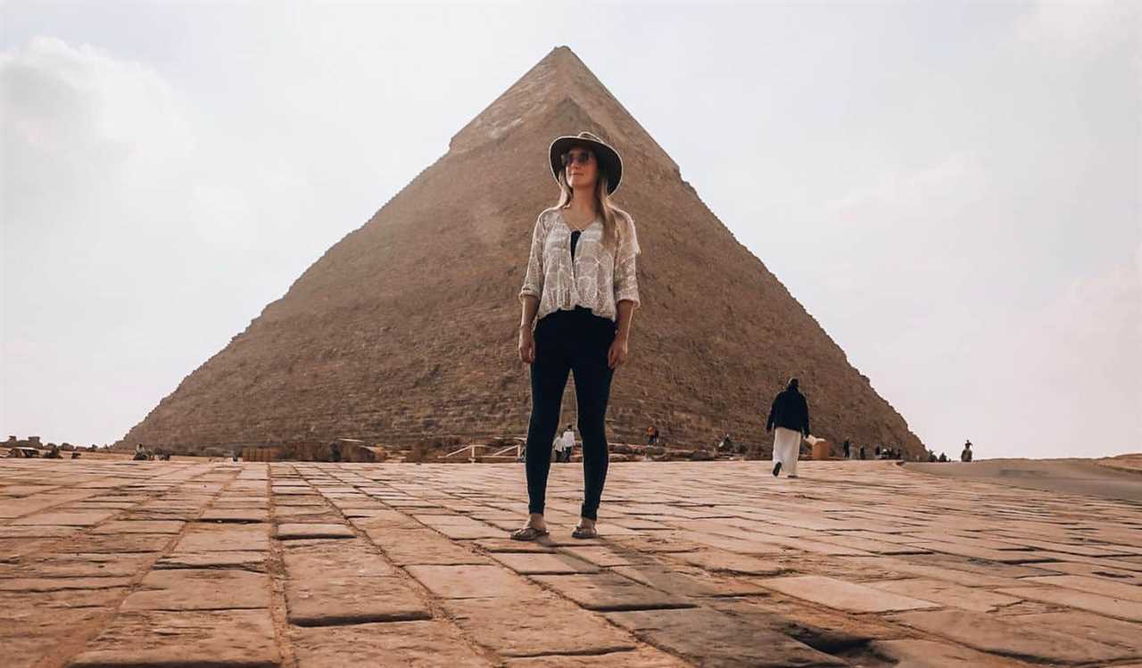 A solo female traveler posing near the pyramids in Cairo, Egypt