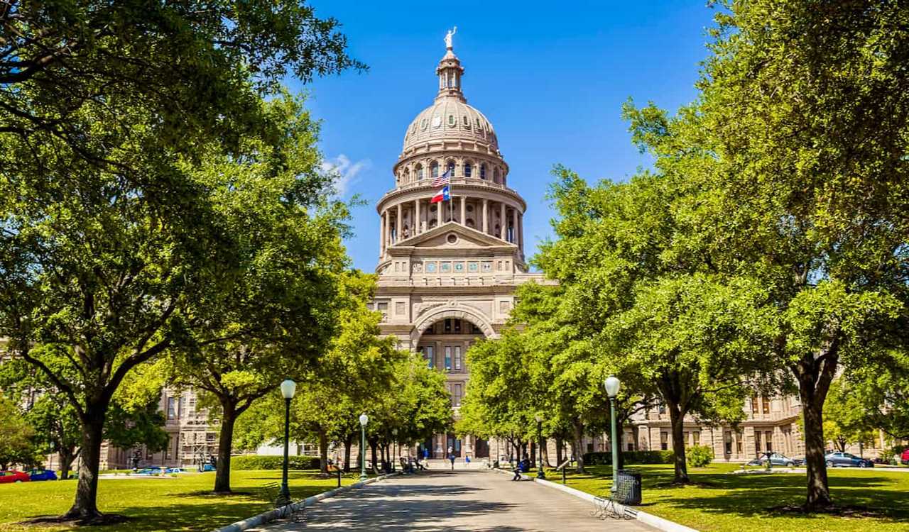 The State Capitol building surrounded by trees and greenery in Austin, Texas