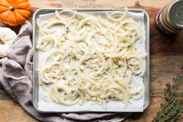 seasoned white onion pieces on a baking sheet