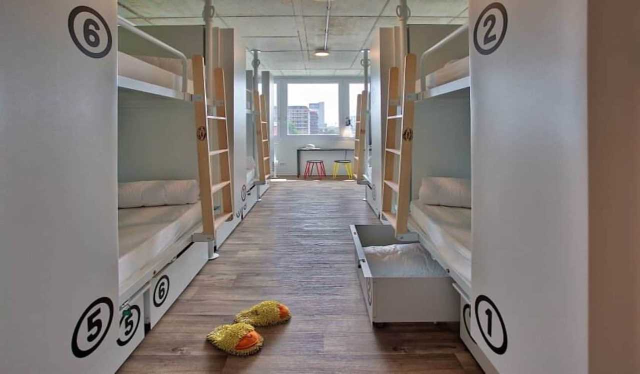 White pod-style bunk beds in a brightly lit room at Anda hostel in Venice, Italy.