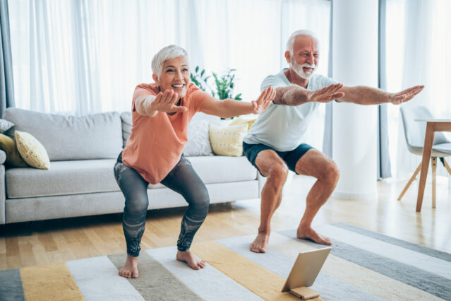 Couple doing squats in their living room