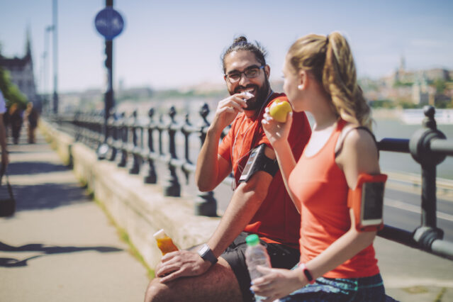 Man and woman eating outside before working out