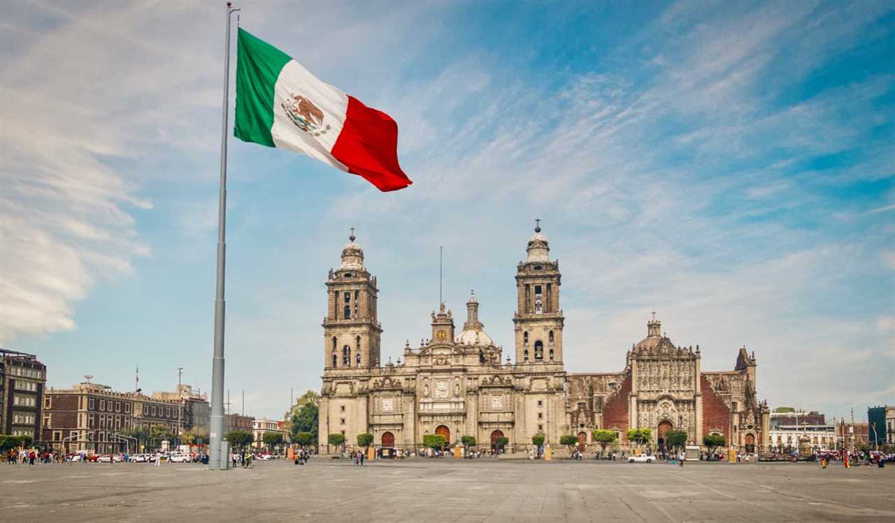 A large Mexican flag in front of one of the many historic buildings in Mexico City, Mexico