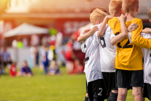 Kids sport team gathering outside during a soccer game