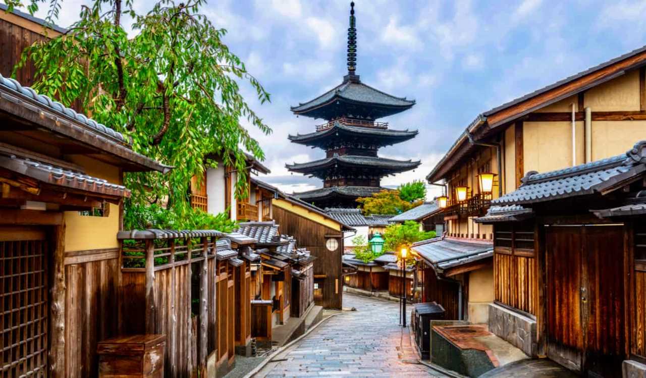 A narrow, old street in quiet Kyoto, Japan with a pagoda in the distance