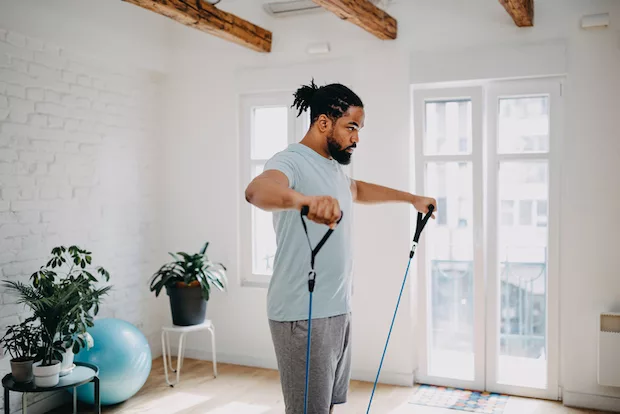 Man doing resistance training exercises at home for his weight loss plan