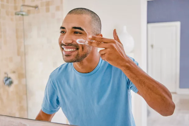 Man in bathroom applying topical zinc for acne