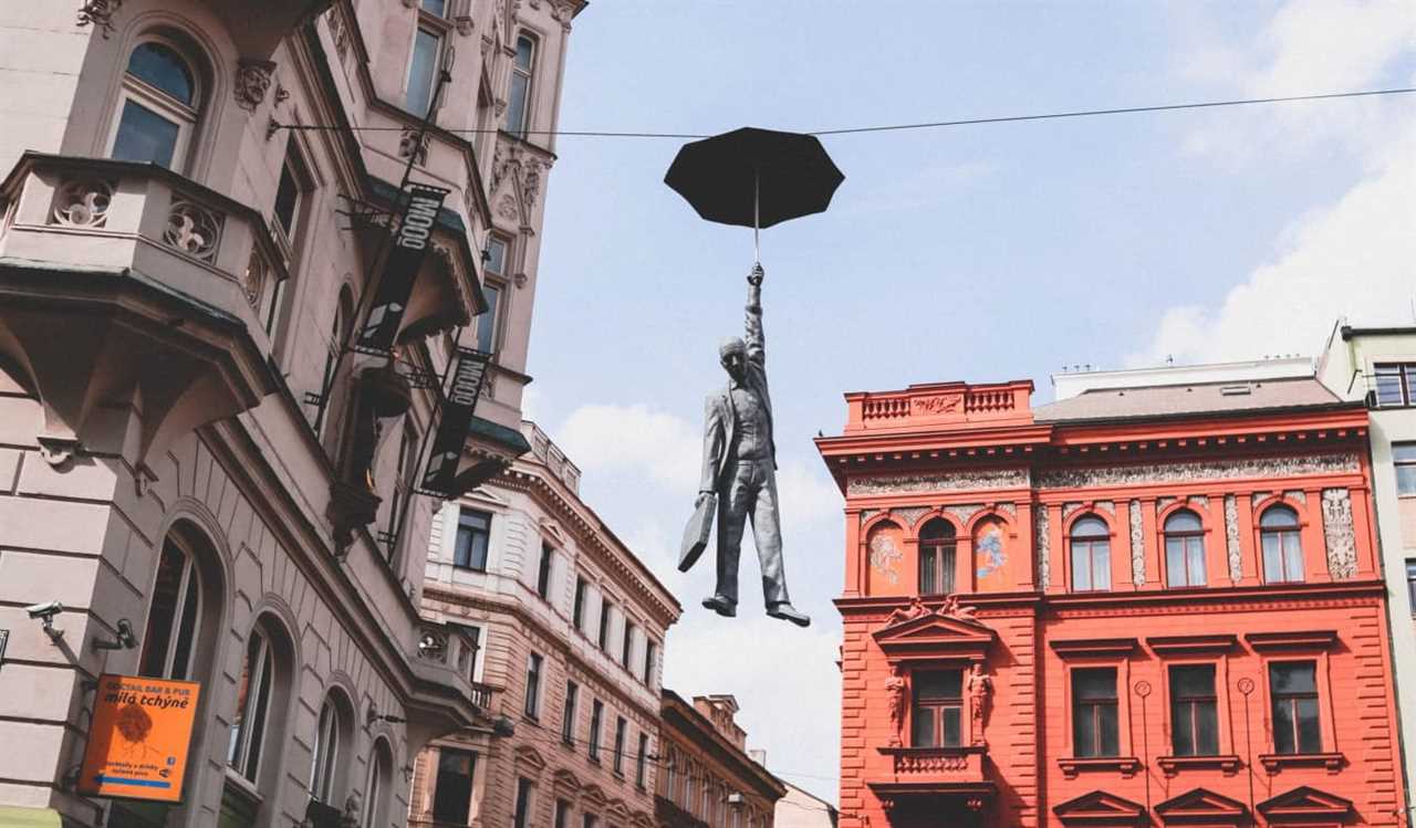 Statue of a man hanging from a telephone line from an umbrella in Prague, Czech Republic