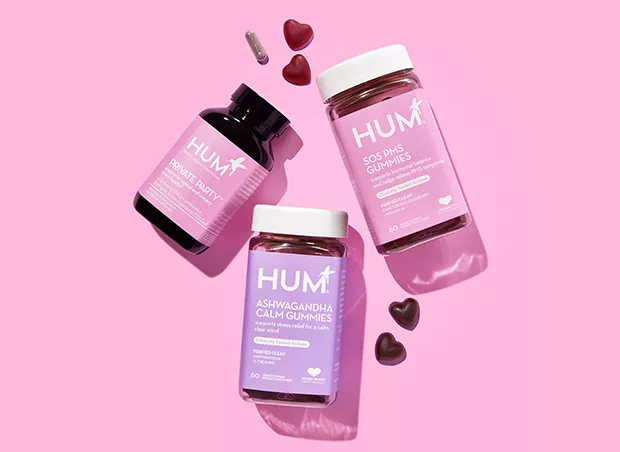 HUM Nutrition SOS PMS gummies, ashwagandha gummies, and Private Party supplements on pink background