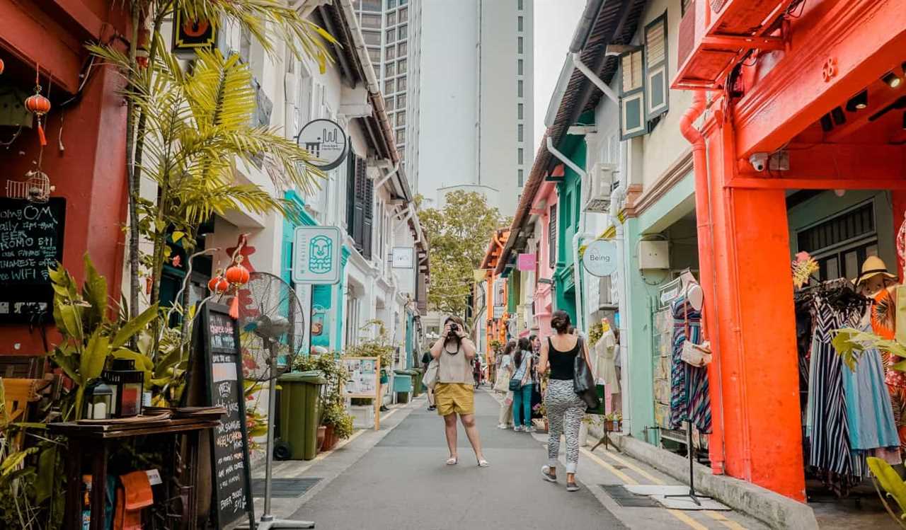 People taking photos and walking down Haji Lane, a pedestrian alley lined with colorful shops and stalls in the neighborhood of Kampong Glam, Singapore
