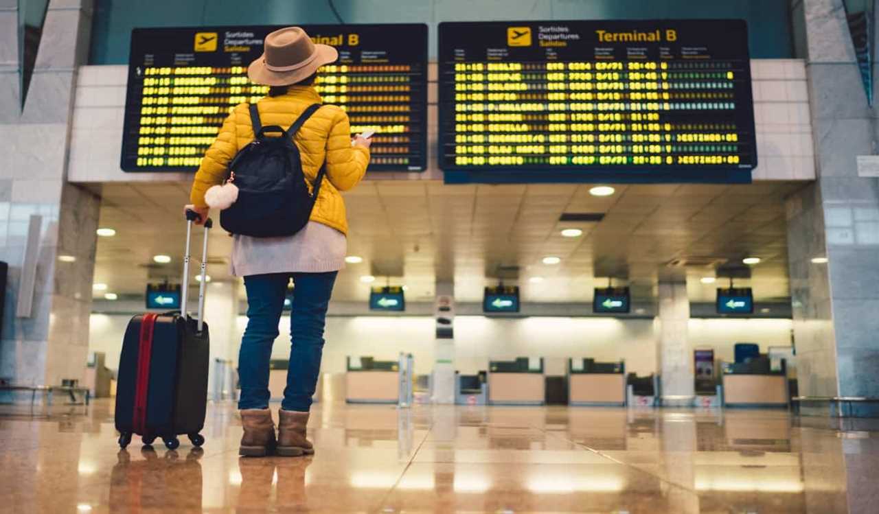 woman standing in front of departures board at Barcelona airport