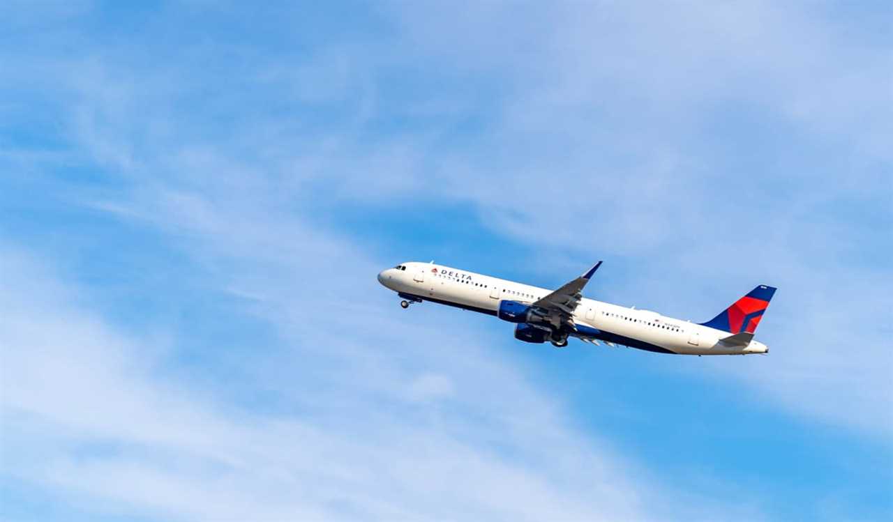 A Delta airplane climbing into a bright blue sky after takeoff in the USA