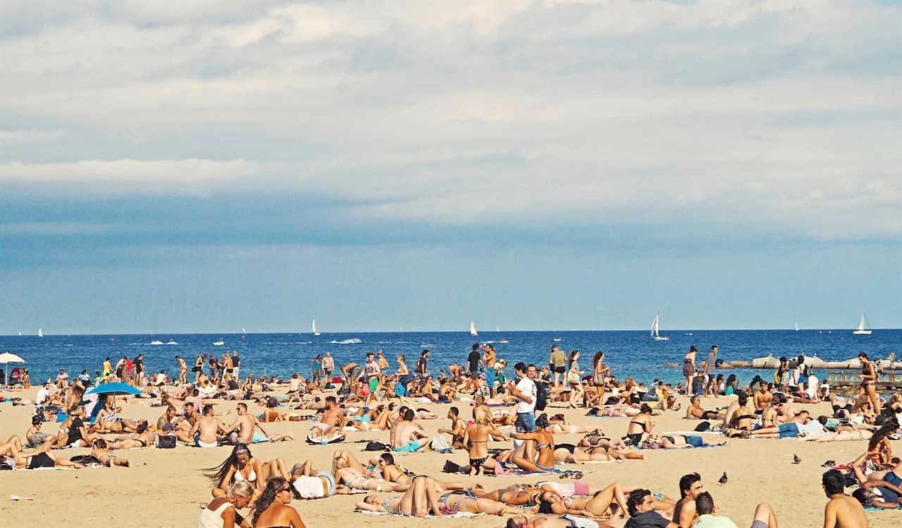 People chilling on the beach in Barcelona, Spain