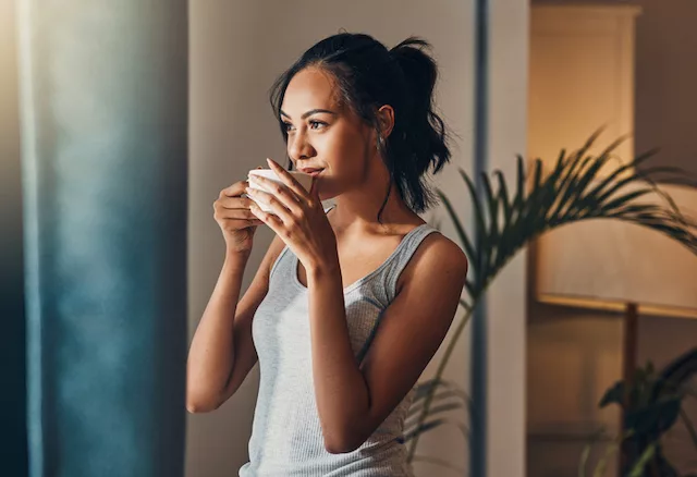 Woman drinking coffee while intermittent fasting to support weight loss