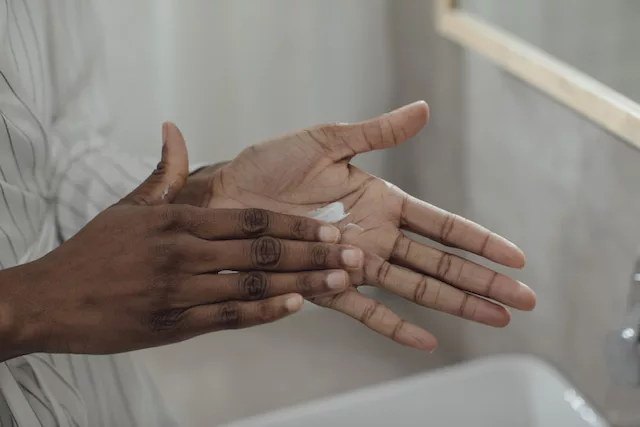 Woman applying lotion with shea butter, which is a pore clogging ingredient