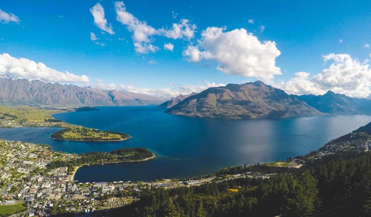Aerial view of Queenstown, New Zealand, showing the city on the water with mountains in the background