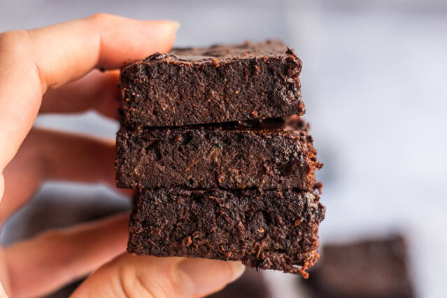 Hand holding 3 keto brownies.