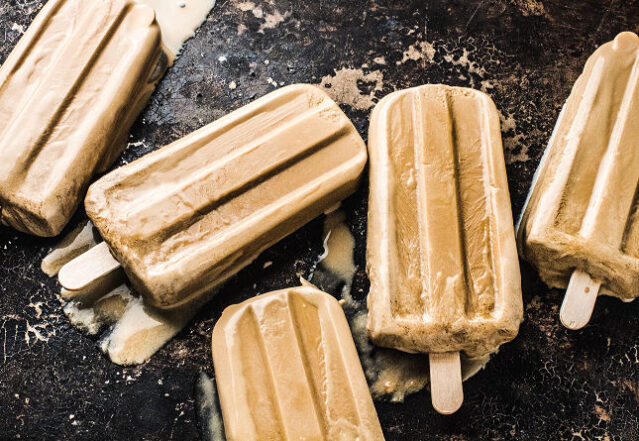 Five frozen keto coffee pops on a black background.