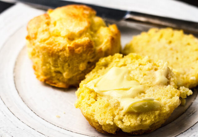 Close-up shot of keto biscuits slathered with butter.