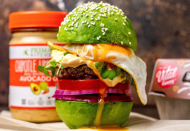 Burger served on an avocado "bun" with a fried egg and Primal Kitchen Chipotle Lime Mayo.