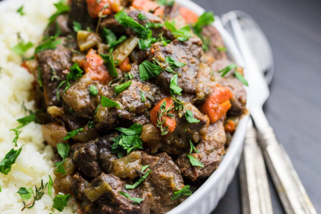 Bowl of keto beef stew with fork and spoon.