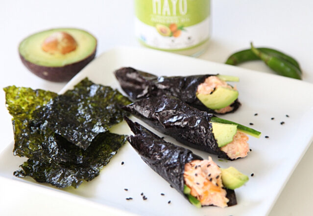 Three smoked salmon hand rolls on a white plate with nori, fresh avocado, and Primal Kitchen Mayo.