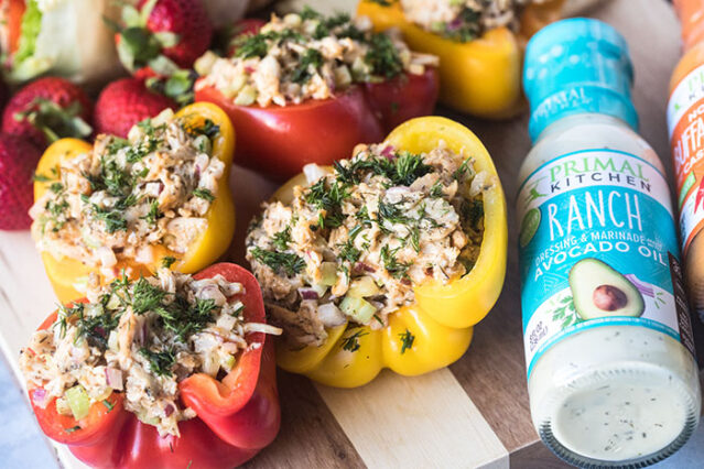 Buffalo chicken stuffed peppers next to bottle of Primal Kitchen ranch dressing.